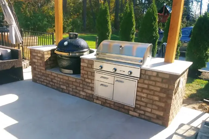 Custom stone grill island with integrated Big Green Egg and timber pergola in Columbus Ohio