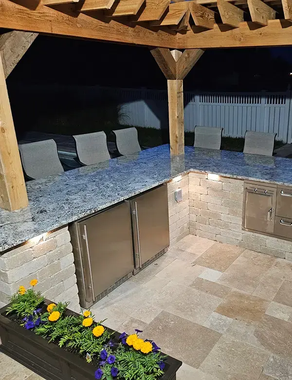 Outdoor kitchen with integrated LED under-counter lighting and granite bar top